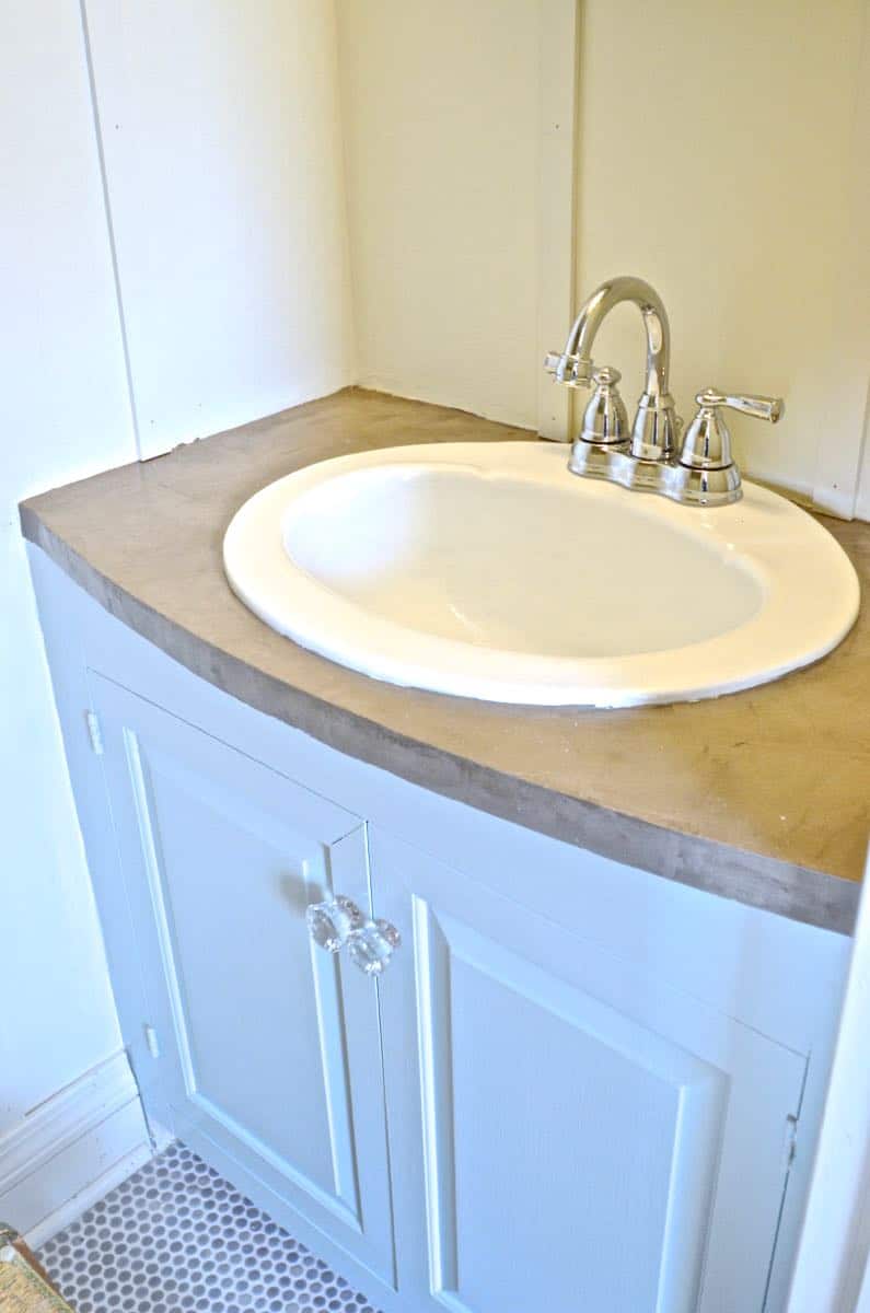 How to transform and old vanity top with concrete for a budget bathroom makeover.