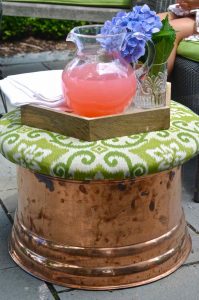 This copper garden hose cover got a makeover as an upholstered storage ottoman for our patio.