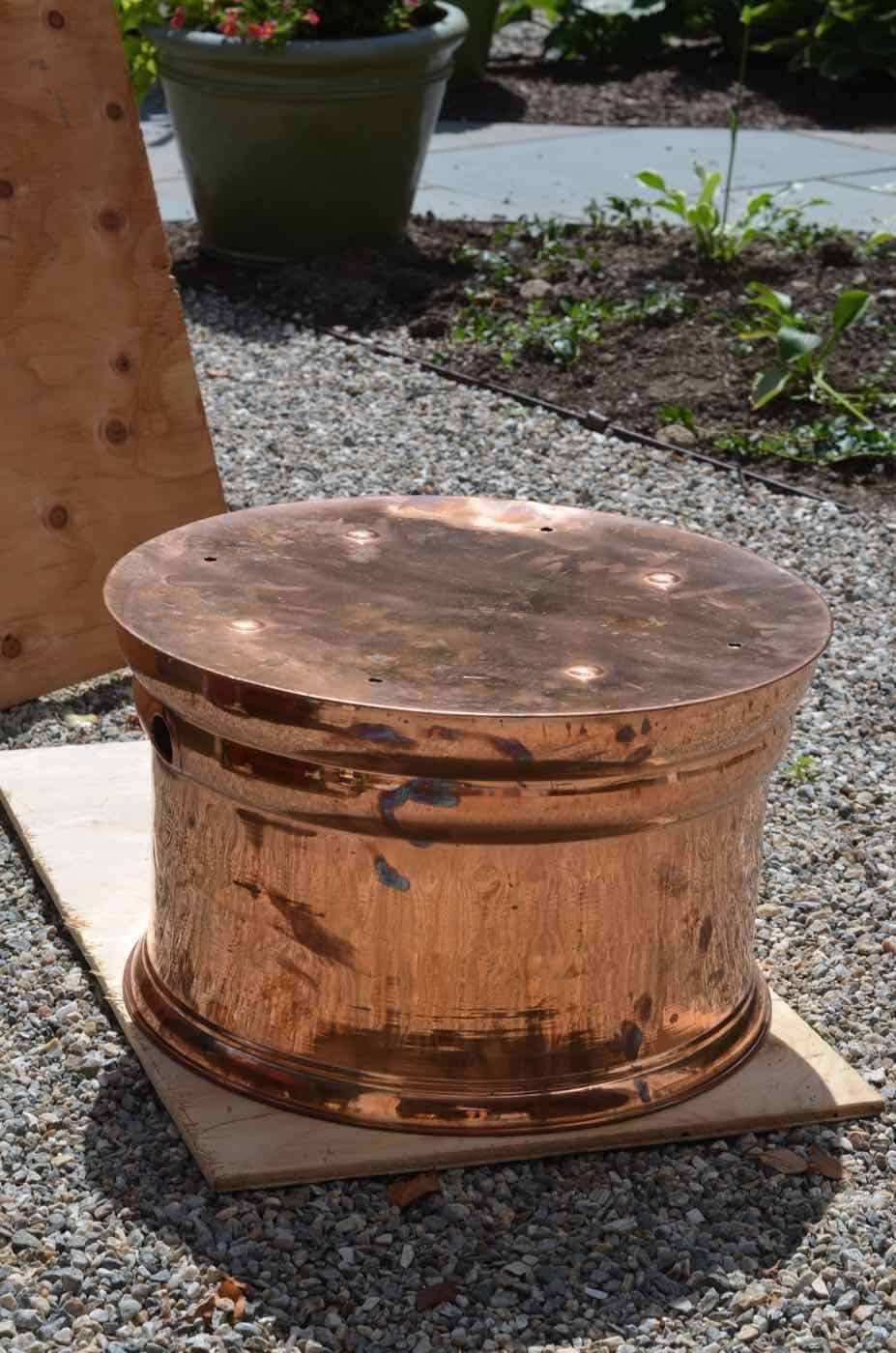 This copper garden hose cover got a makeover as an upholstered storage ottoman for our patio.