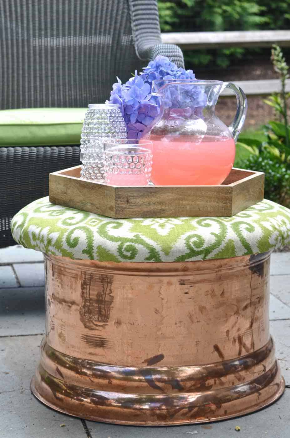 This copper garden hose cover got a makeover as an upholstered storage ottoman for our patio.