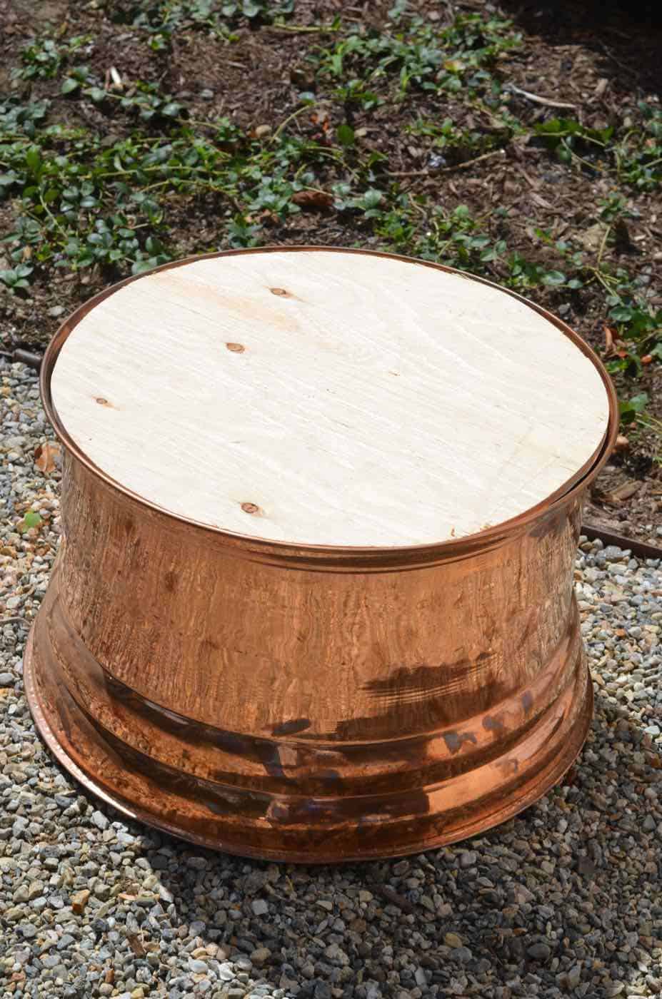 This copper garden hose cover got a makeover as an upholstered storage ottoman for our patio.