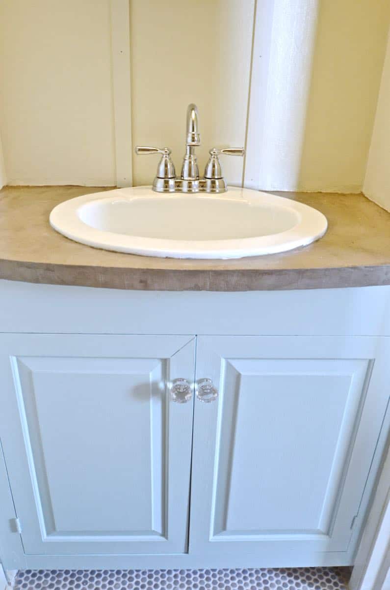 How to transform and old vanity top with concrete for a budget bathroom makeover.