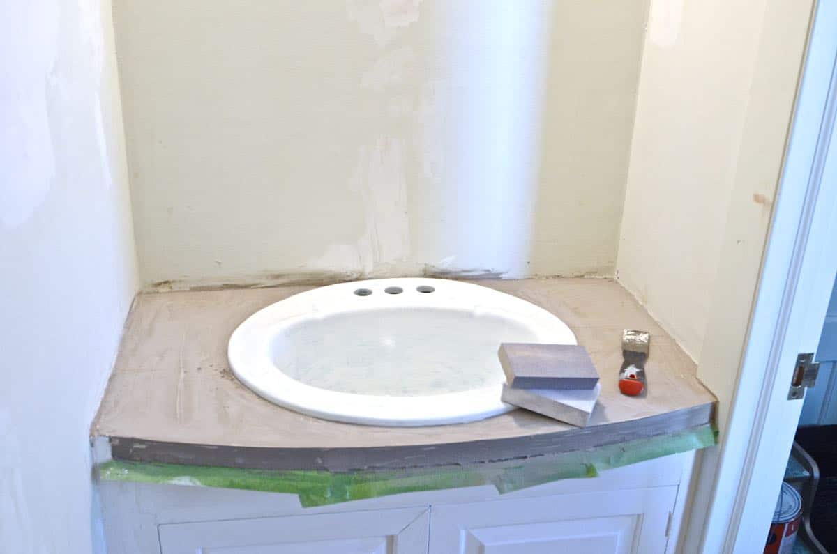 How to transform and old vanity top with concrete for a budget bathroom makeover.