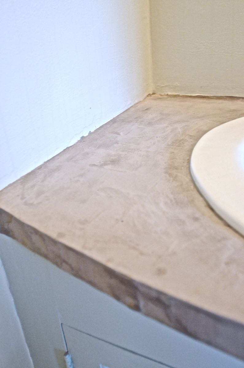 How to transform and old vanity top with concrete for a budget bathroom makeover.