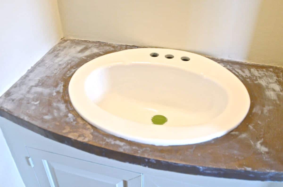 How to transform and old vanity top with concrete for a budget bathroom makeover.