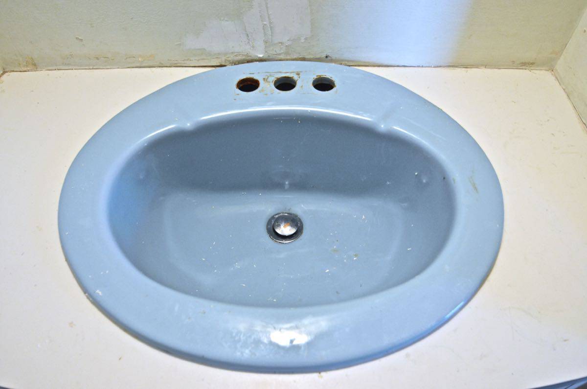 Paint a sink to look new and updated without spending a dime on plumbing.