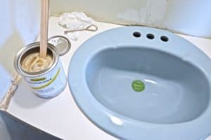 Paint a sink to look new and updated without spending a dime on plumbing.