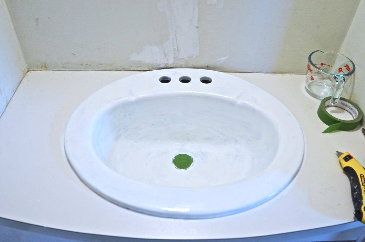 Paint a sink to look new and updated without spending a dime on plumbing.