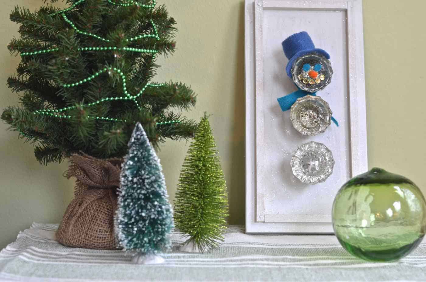 Transform thrifted glass doorknobs into repurposed Christmas snowman.