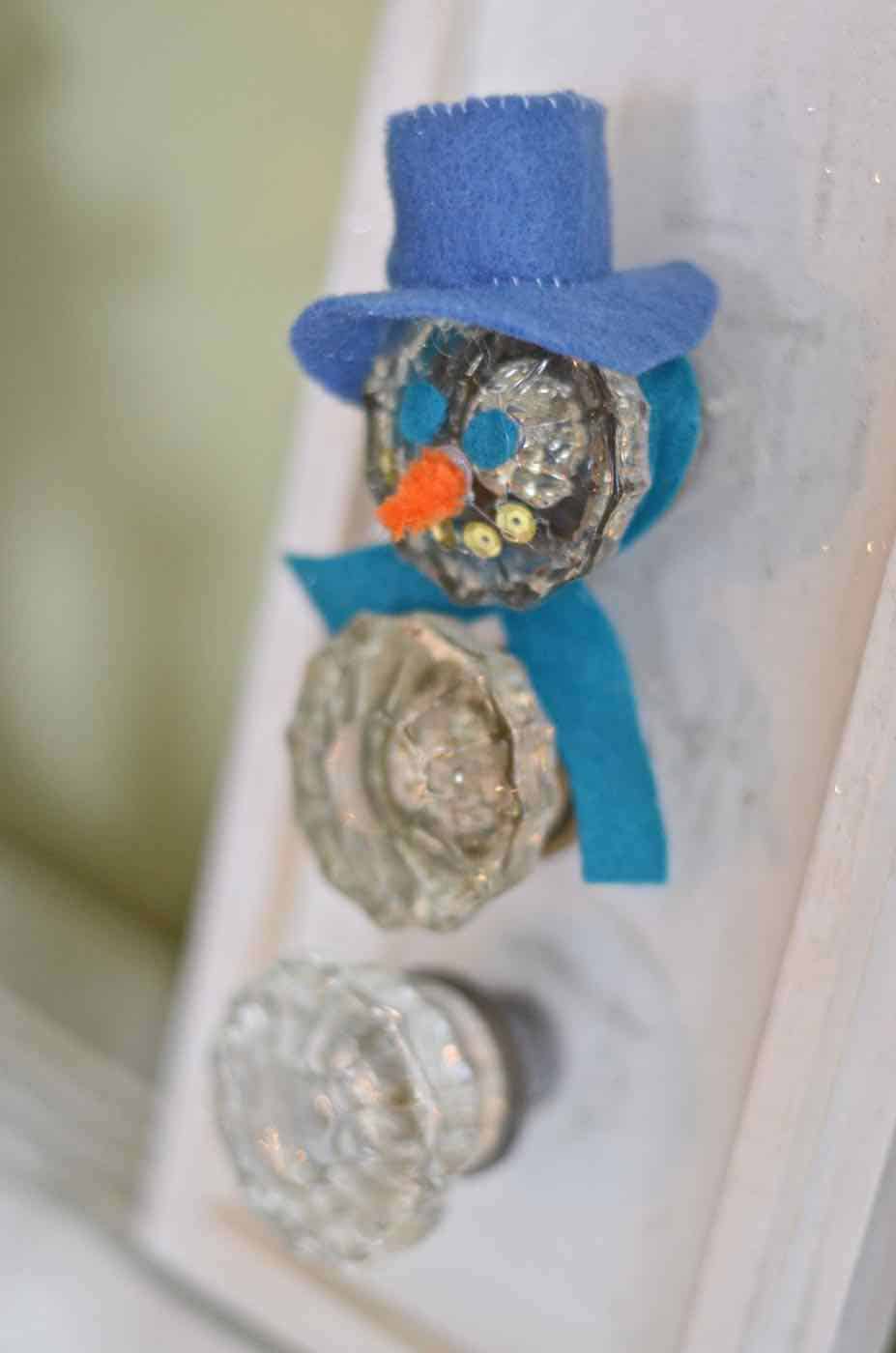 Transform thrifted glass doorknobs into repurposed Christmas snowman.