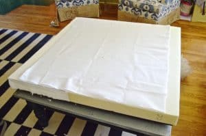 Turn a basic coffee table into an upholstered ottoman.