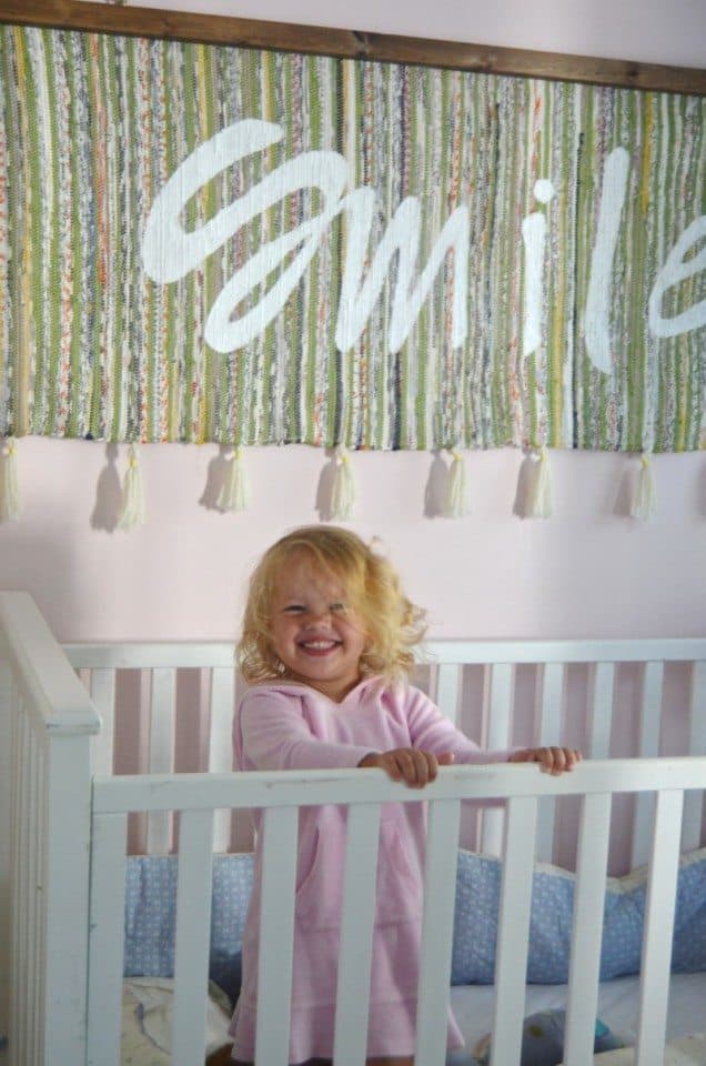 girl smiling in crib boho nursery