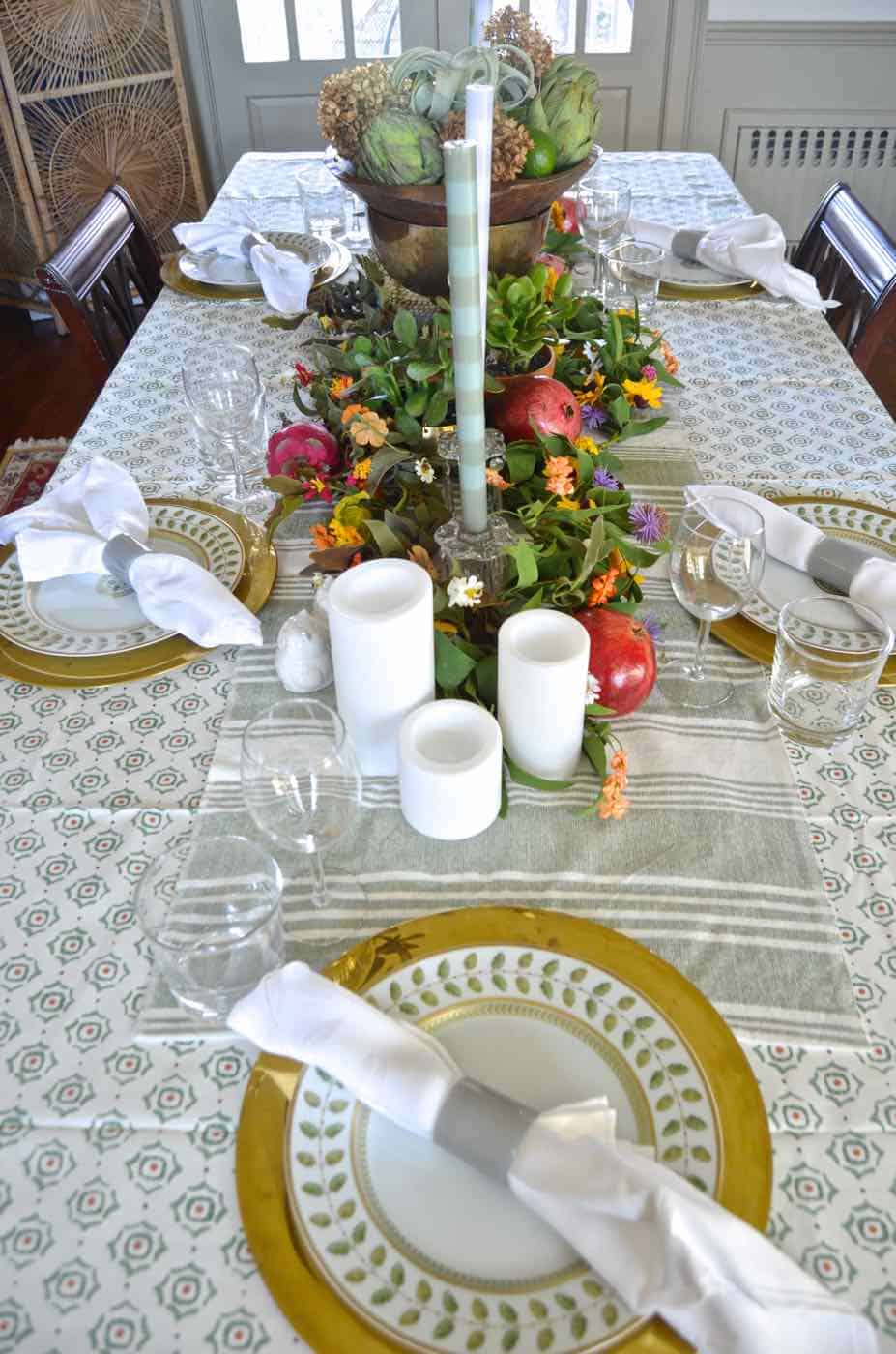 Thanksgiving tablescape with lush greenery and vegetables.