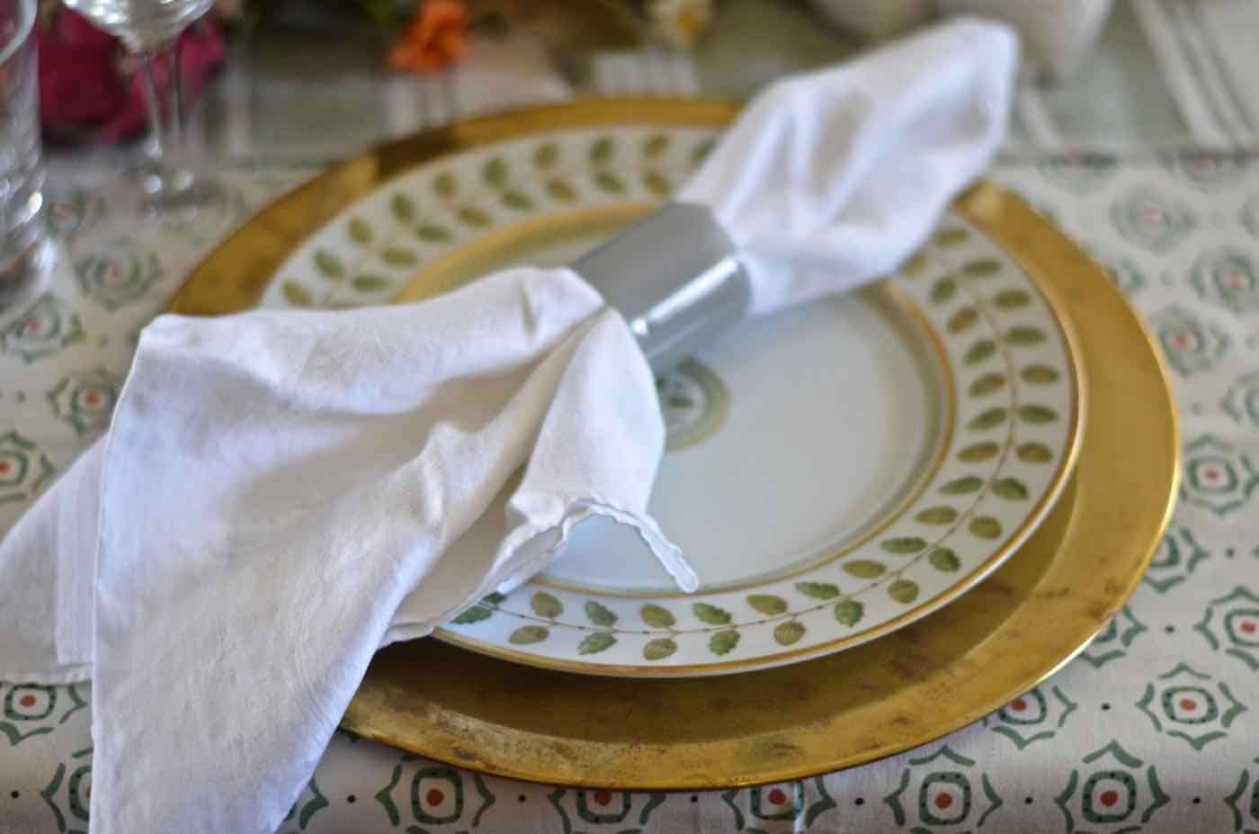 Thanksgiving tablescape with lush greenery and vegetables.