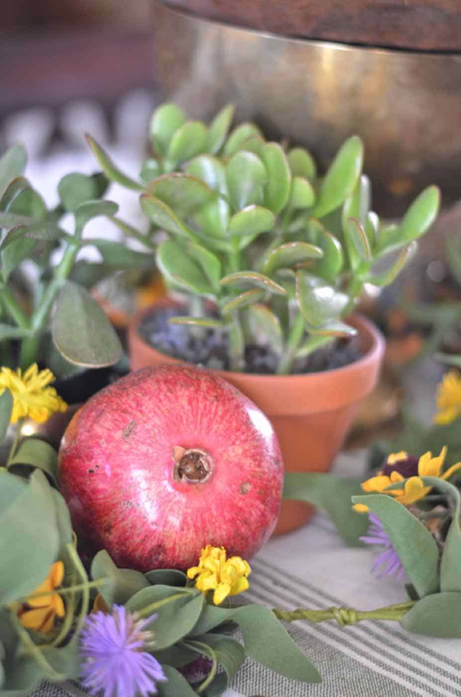 Thanksgiving tablescape with lush greenery and vegetables.