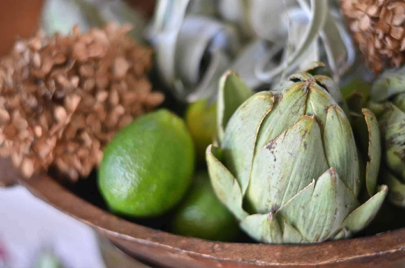 Thanksgiving tablescape with lush greenery and vegetables.