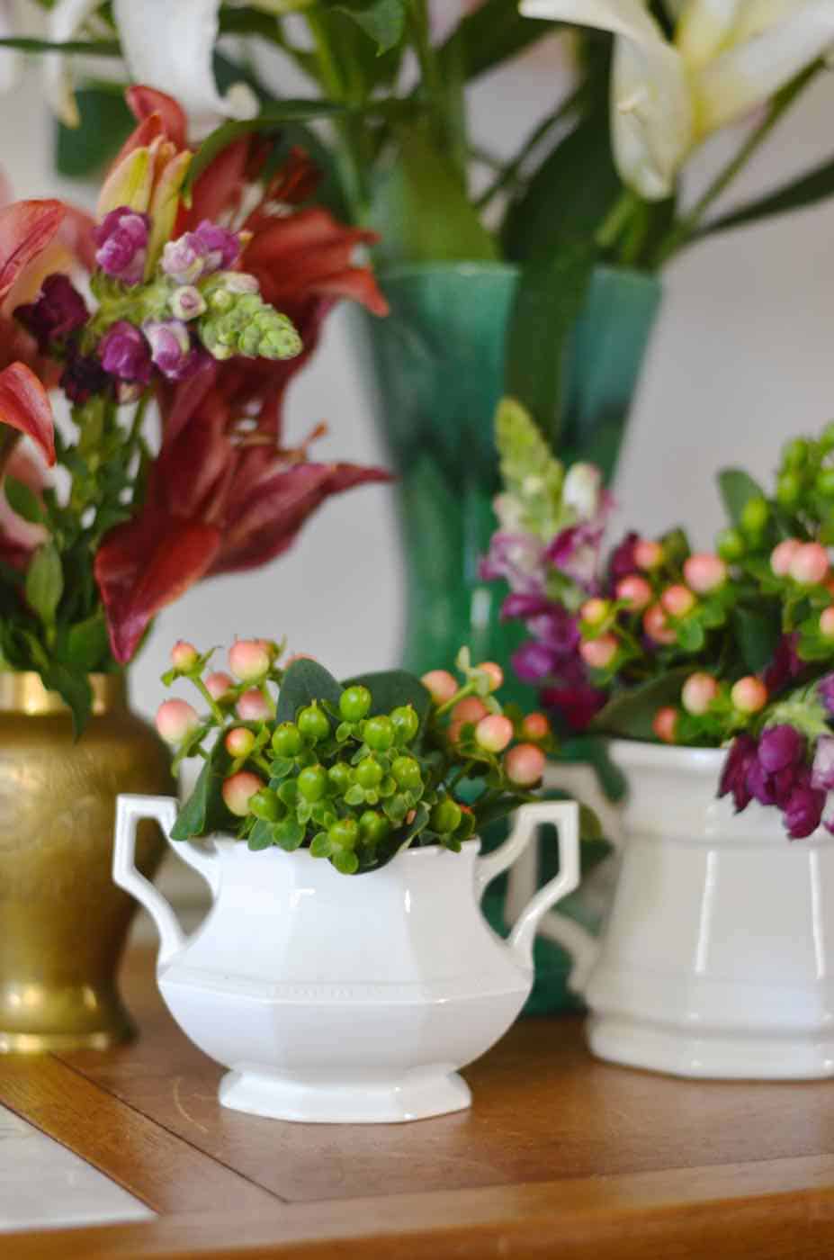 Thanksgiving tablescape with lush greenery and vegetables.