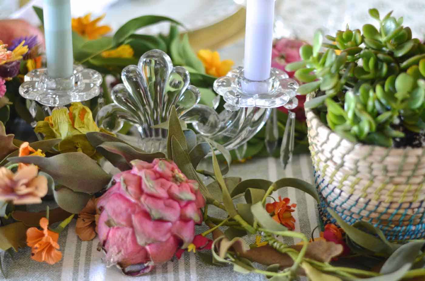 Thanksgiving tablescape with lush greenery and vegetables.