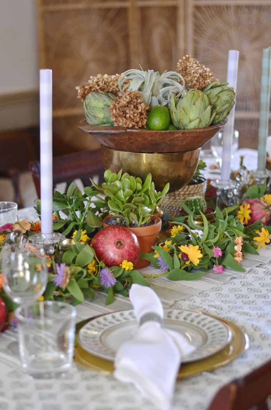 Thanksgiving tablescape with lush greenery and vegetables.