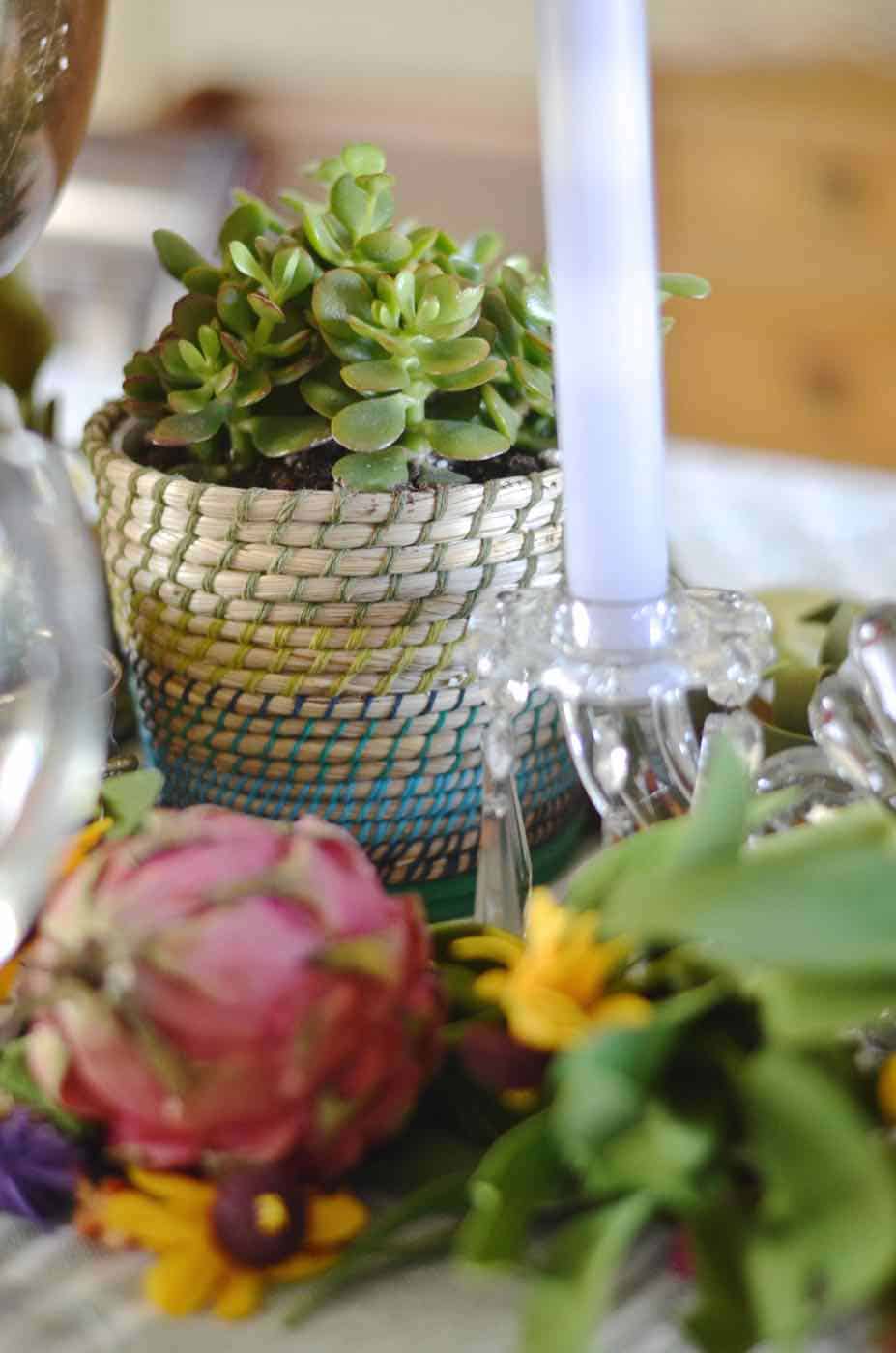 Thanksgiving tablescape with lush greenery and vegetables.