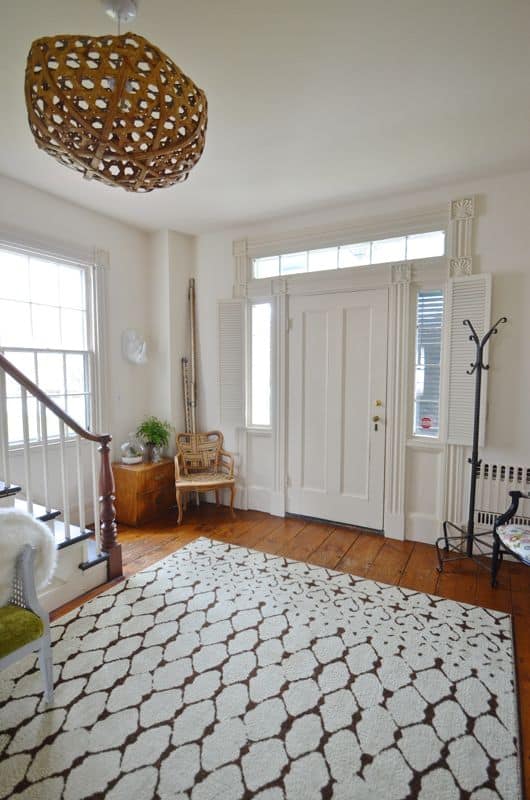 Eclectic foyer pulled together with refurbished furniture and fun fabric and accessories.