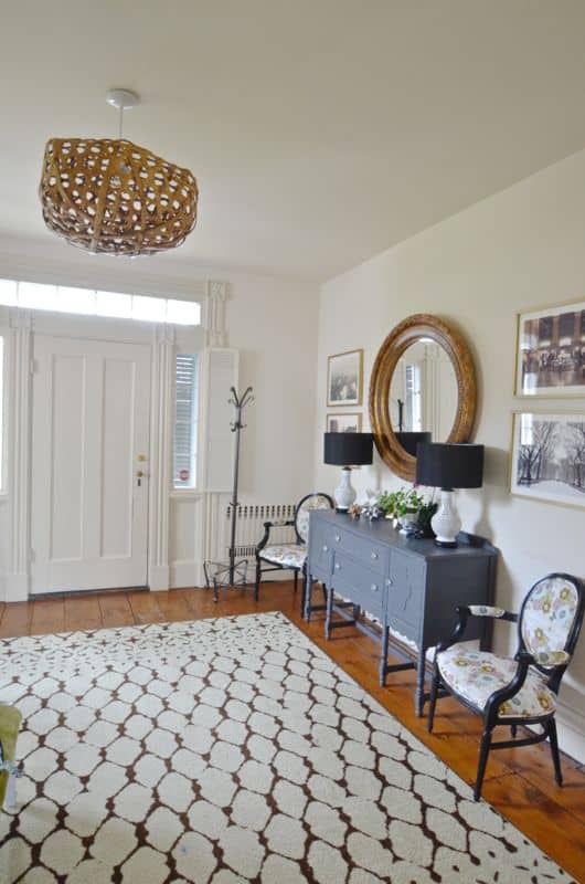 Eclectic foyer pulled together with refurbished furniture and fun fabric and accessories.