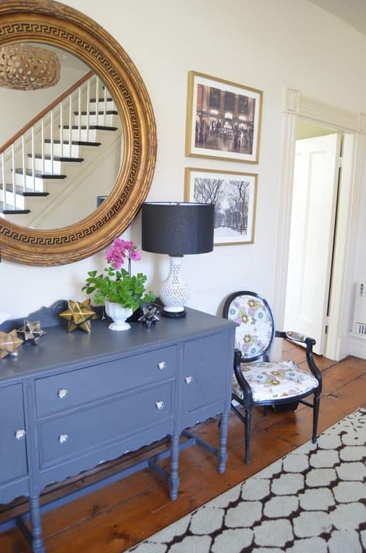 Eclectic foyer pulled together with refurbished furniture and fun fabric and accessories.