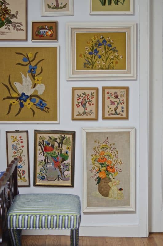 Guest bedroom with mixed patterns and textures. Gallery wall of embroidered art.