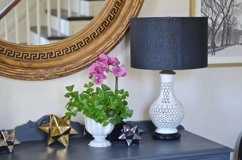 Eclectic foyer pulled together with refurbished furniture and fun fabric and accessories.