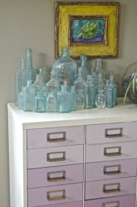 glass bottles on ombre file cabinet