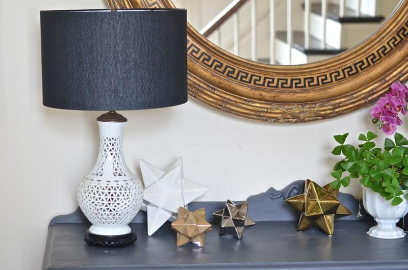 Eclectic foyer pulled together with refurbished furniture and fun fabric and accessories.