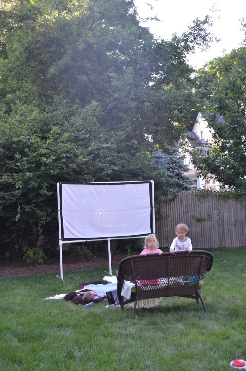 DIY backyard movie screen using PVC pipes and a clearance sheet.