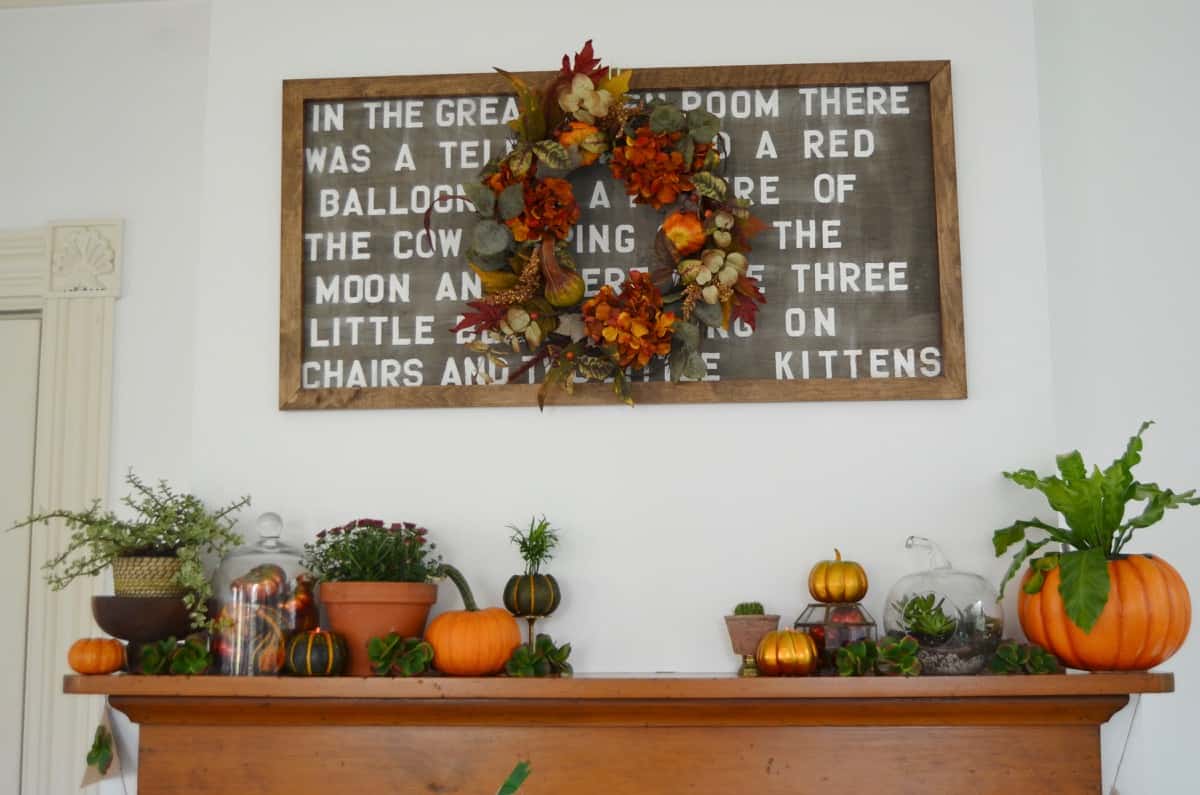 Fall harvest mantel with pumpkins and gourds and succulents.