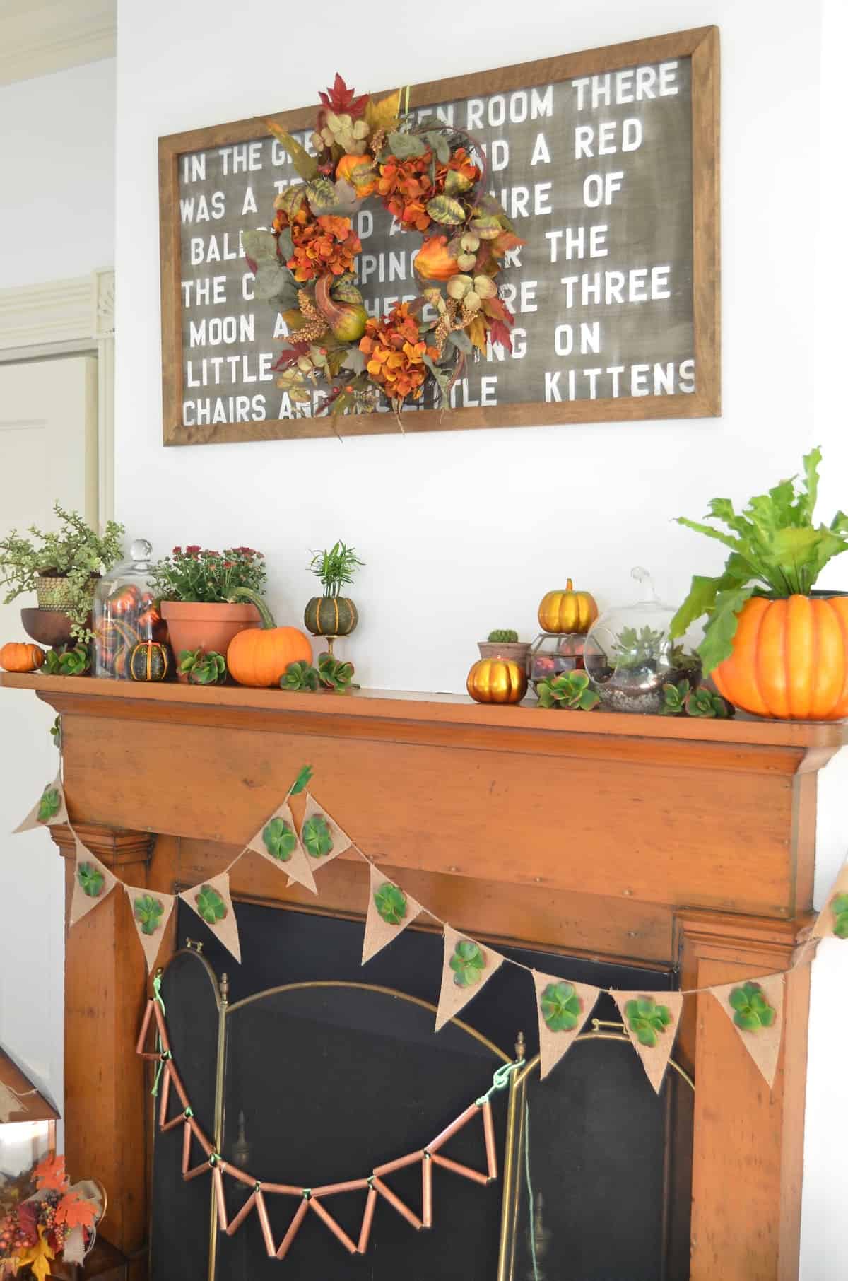 Fall harvest mantel with pumpkins and gourds and succulents.