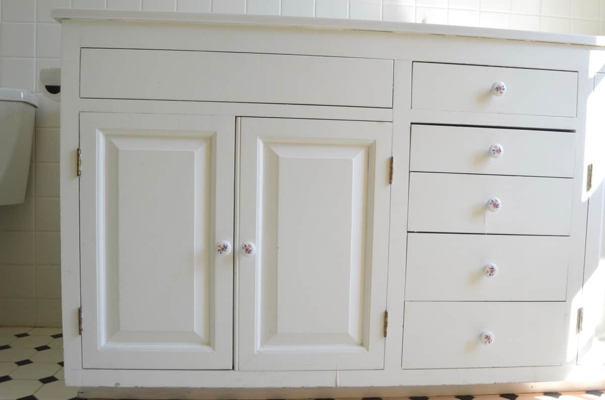 Repainting a basic white vanity with navy blue Satin Enamel paint for an easy bathroom makeover!