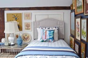 Updated guest room with new upholstered headboards and a repainted rich vintage gallery wall.