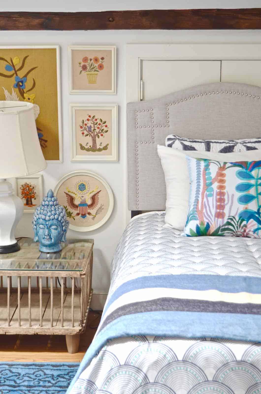 Updated guest room with new upholstered headboards and a repainted rich vintage gallery wall.