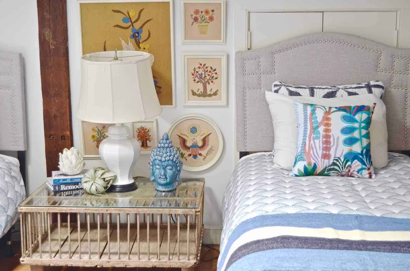 Updated guest room with new upholstered headboards and a repainted rich vintage gallery wall.