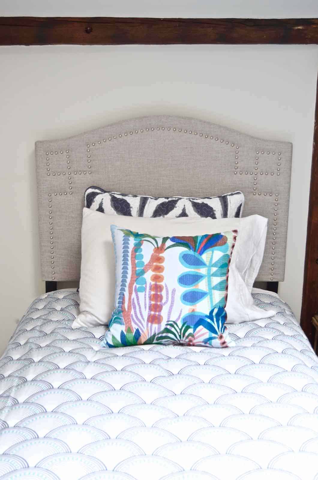 Updated guest room with new upholstered headboards and a repainted rich vintage gallery wall.