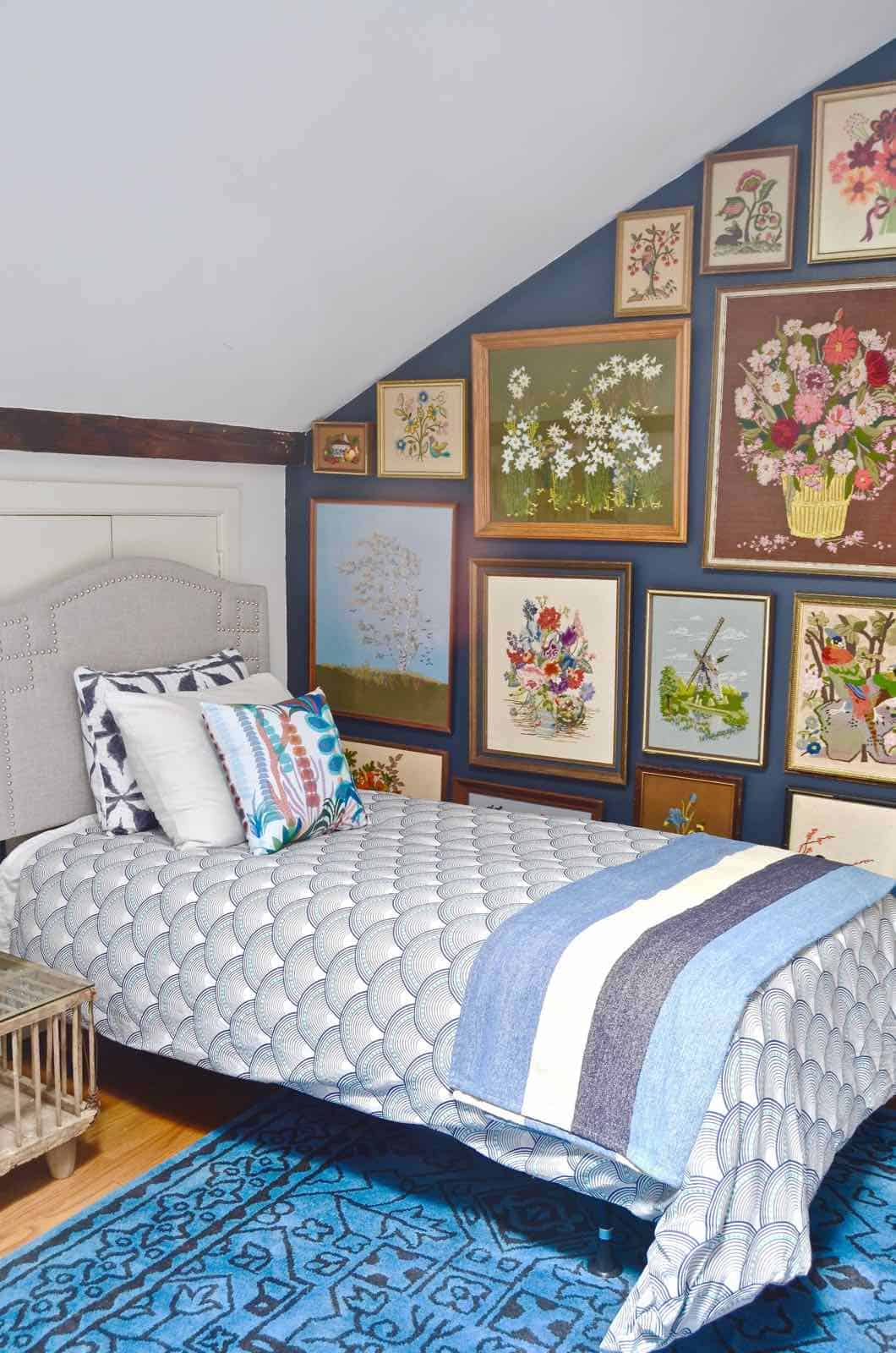 Updated guest room with new upholstered headboards and a repainted rich vintage gallery wall.