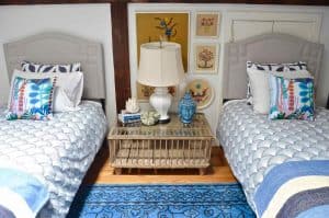 Updated guest room with new upholstered headboards and a repainted rich vintage gallery wall.