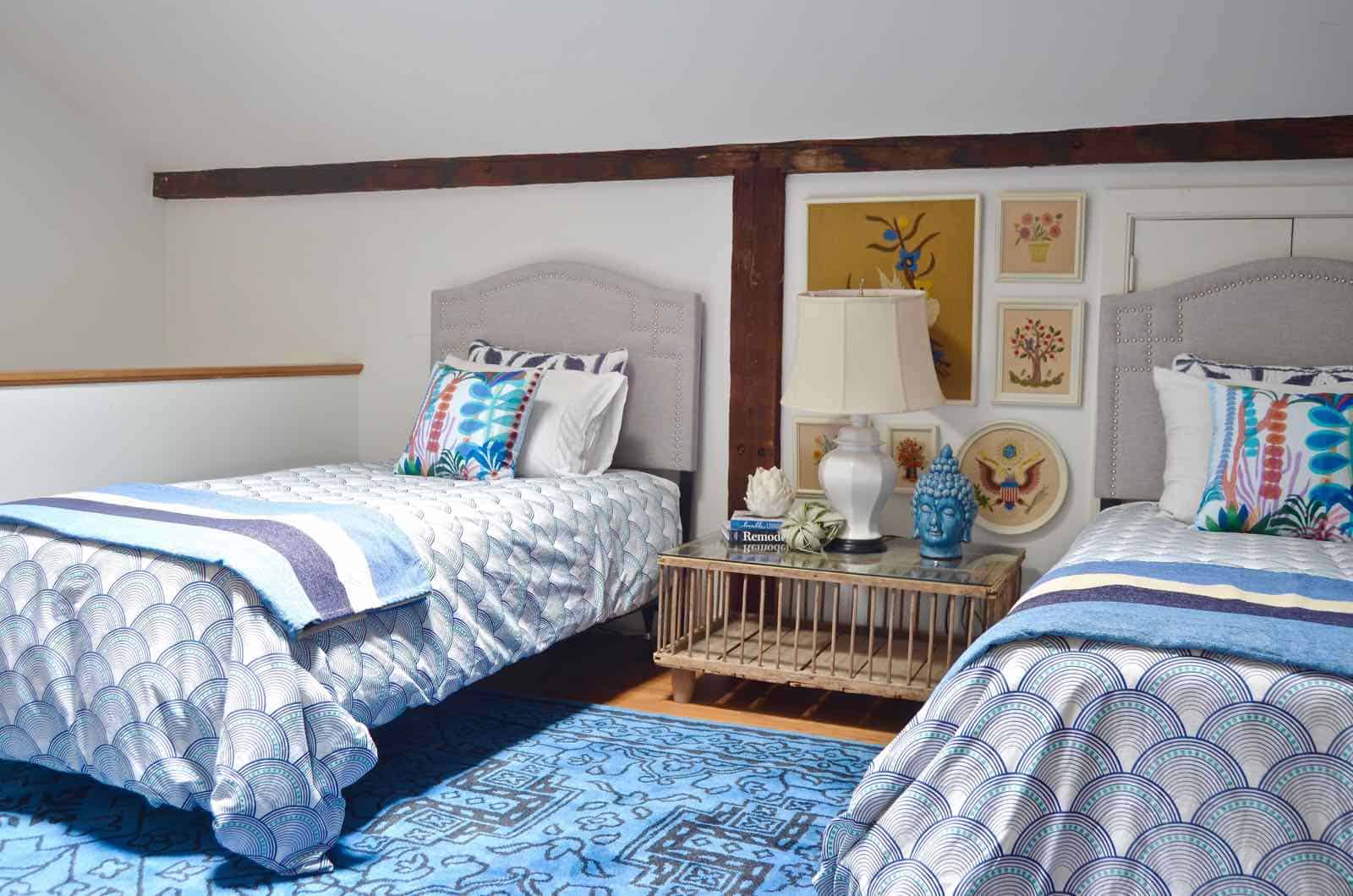 Updated guest room with new upholstered headboards and a repainted rich vintage gallery wall.