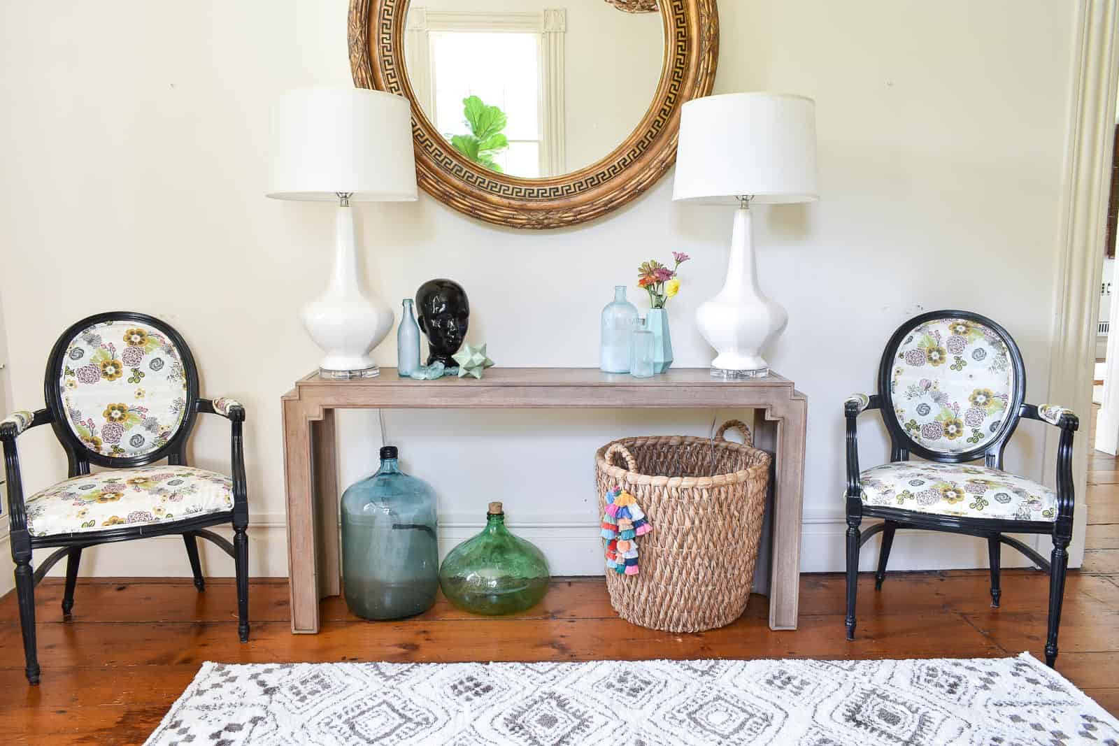 Bassett console table under round antique mirror