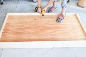 place plywood on bedframe and screw in place