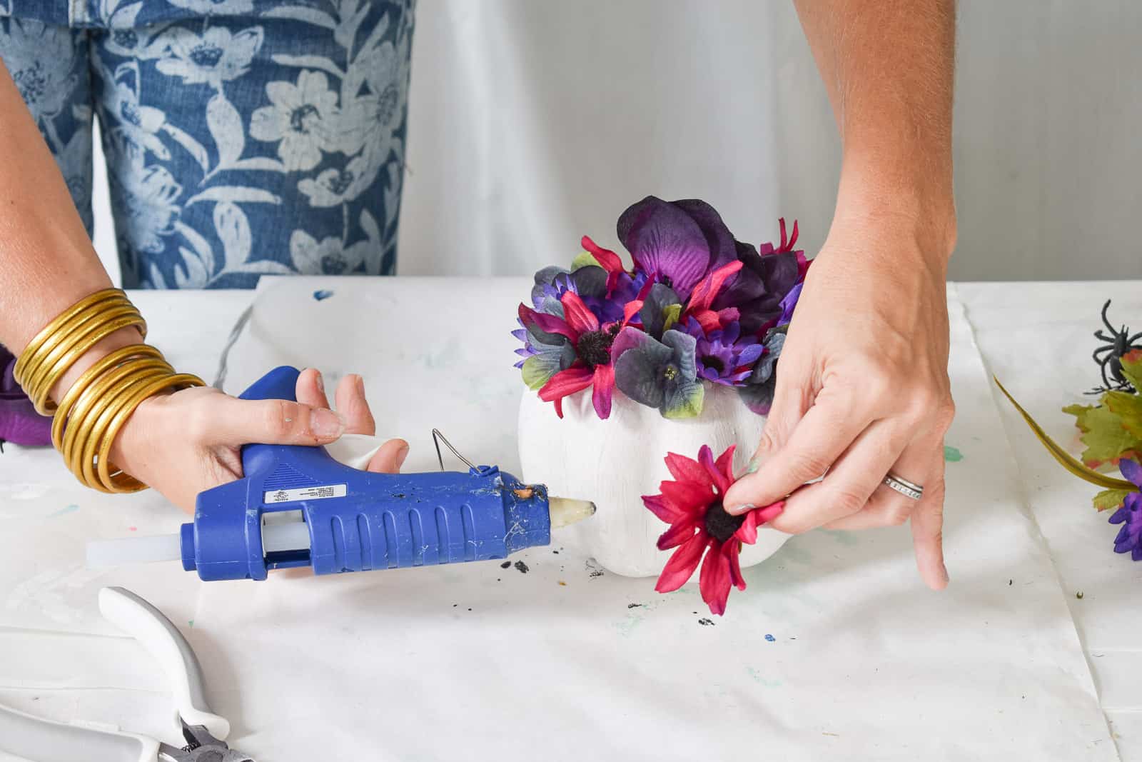 glue gun to place flowers on pumpkins