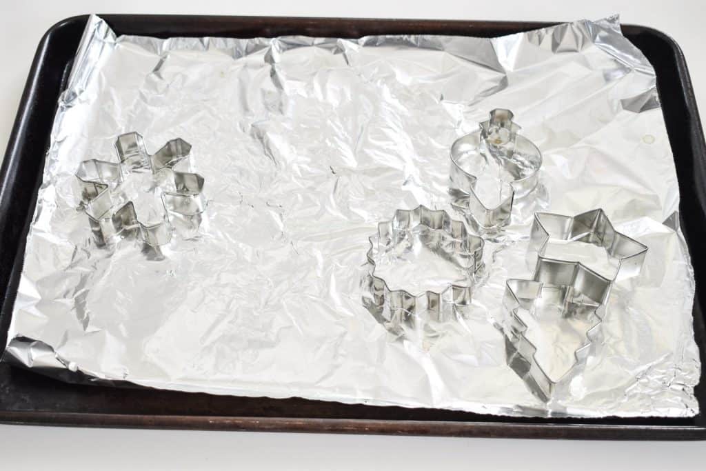 place tin foil and cookie cutters on cookie sheet