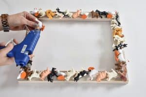 hot glue plastic animals to frame