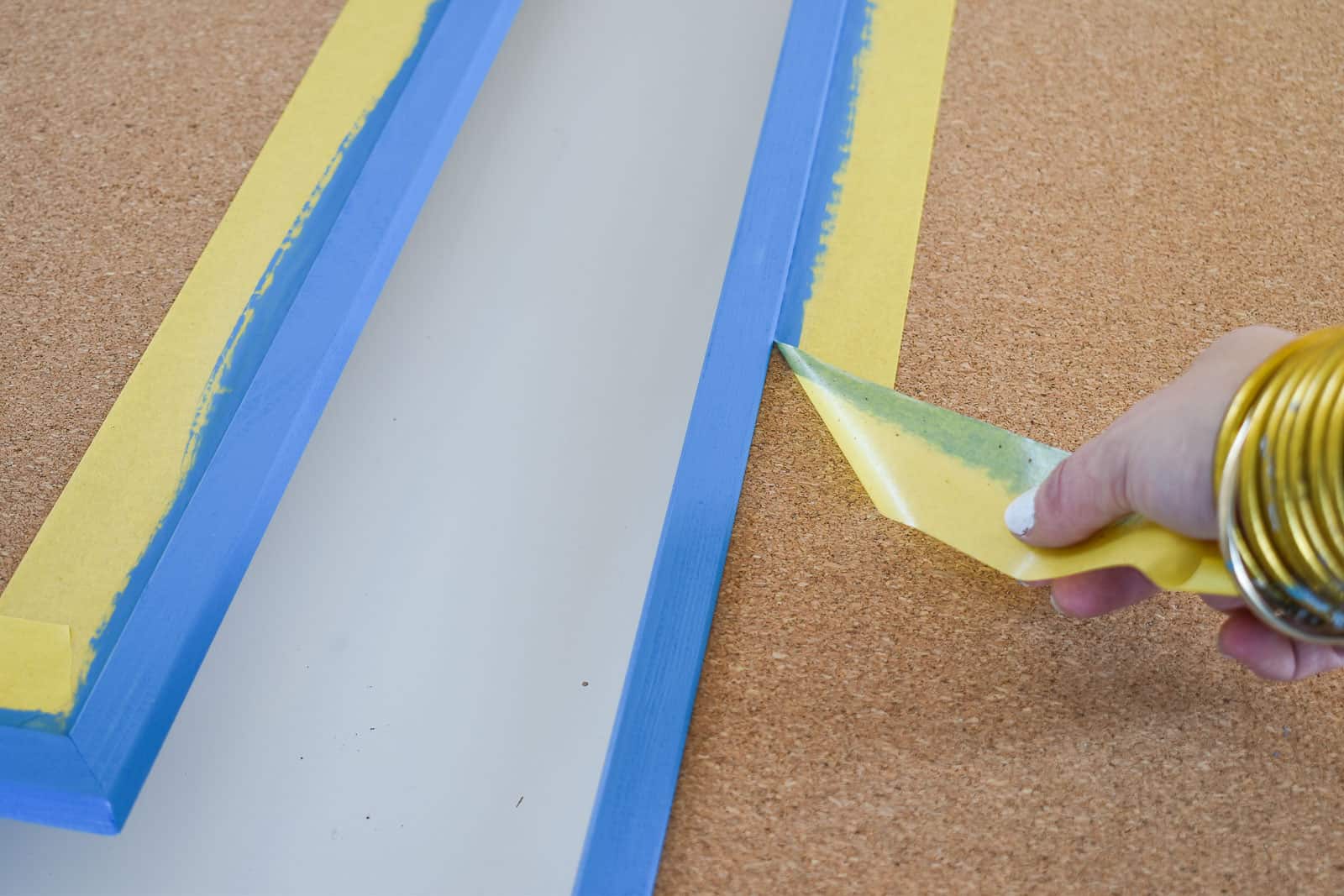 painting a frame on a cork board