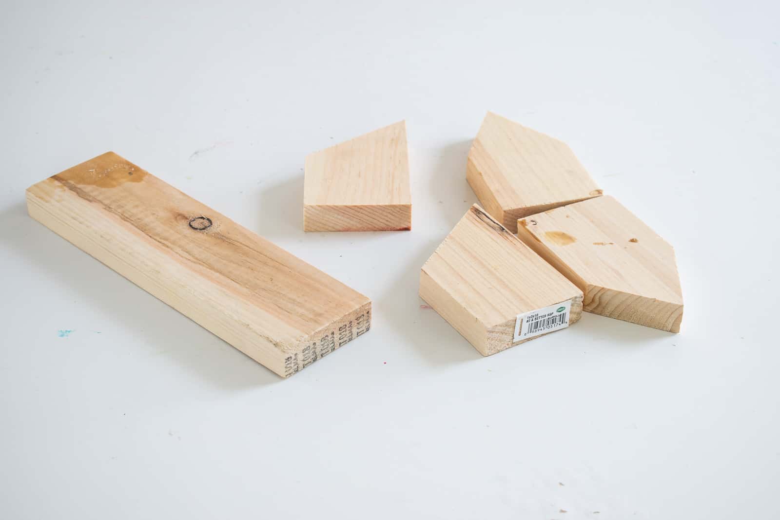 cut scrap wood into house shapes