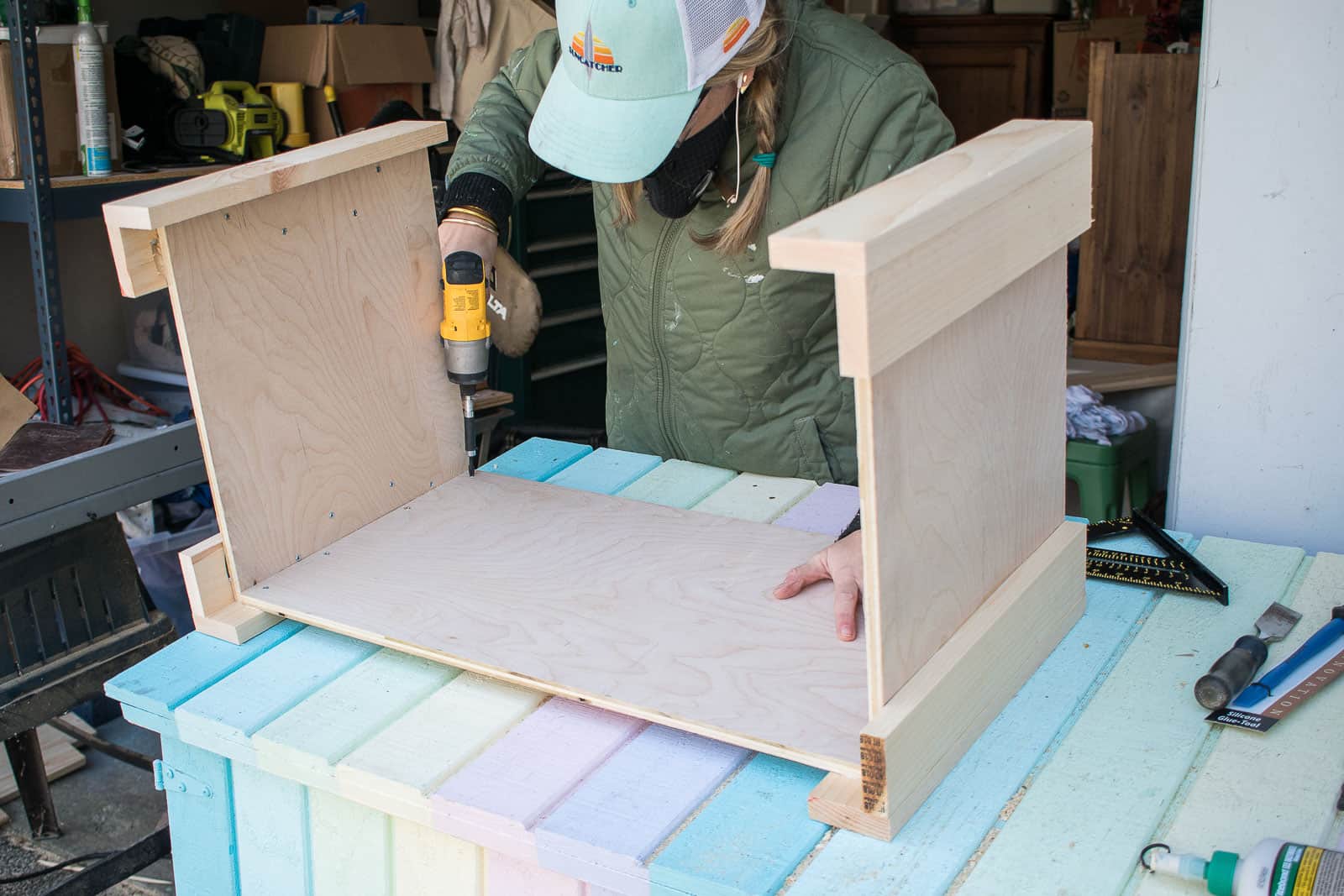 attaching the plywood to the legs of the cooler box